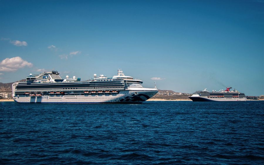Two cruise ships anchored off Cabo San Lucas under a blue sky